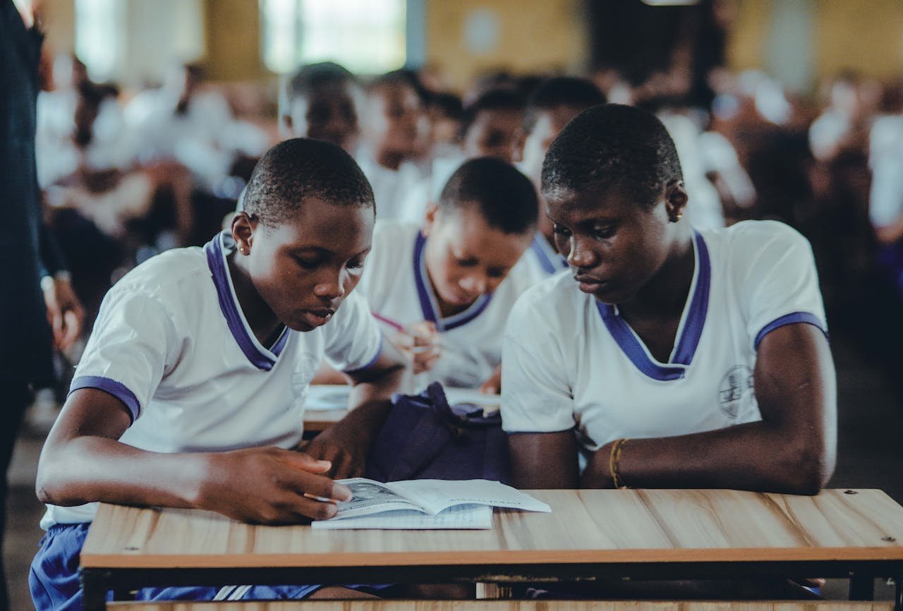 team-02 African students concentrating on their studies in a classroom setting, wearing uniforms.