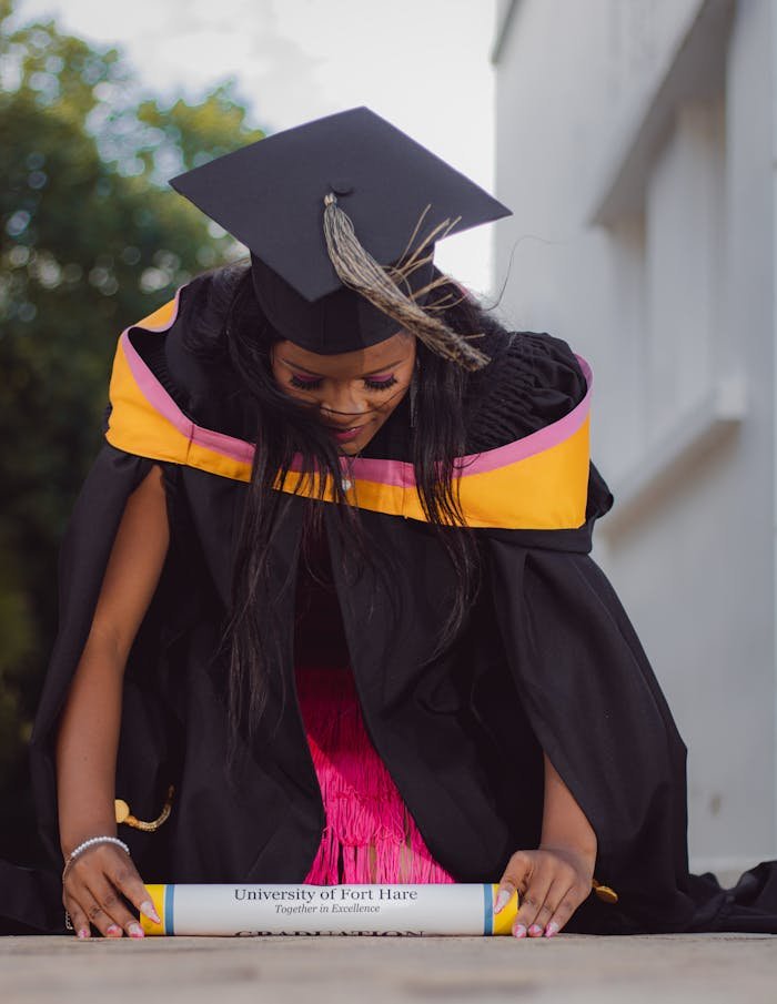 journey A proud graduate from the University of Fort Hare with diploma and cap, celebrating achievement.